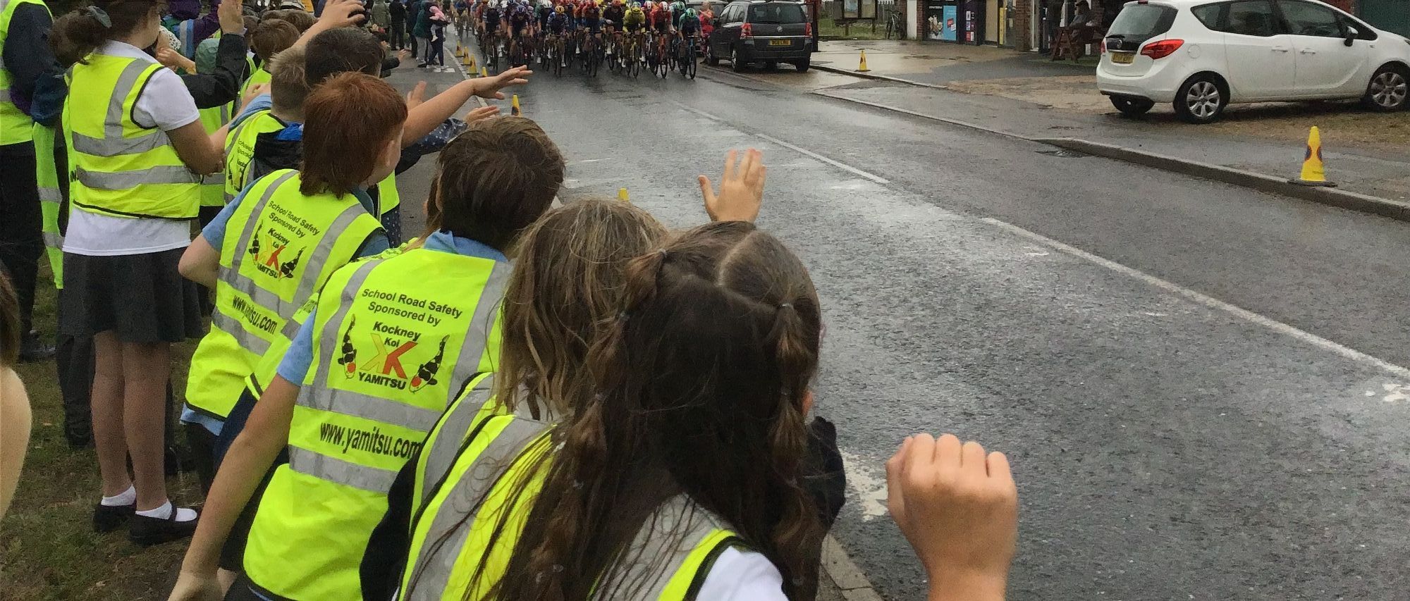 Group of children cheering on the Lloyds Tour of Britain Men's Cycle race as they appear